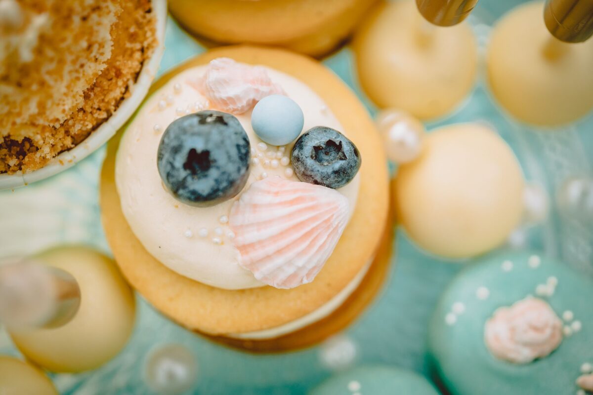 Ein Kuchen mit Blaubeeren und Muscheln darauf.