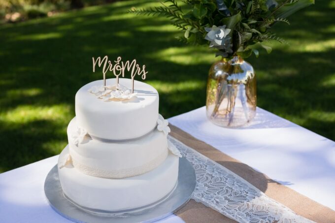 Eine weiße Hochzeitstorte mit einem Mr. und Mrs. Tortenaufsatz.