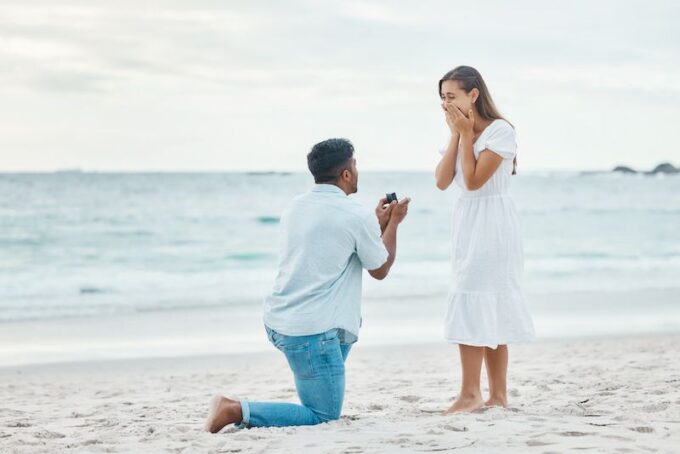 Ein Mann macht einer Frau am Strand einen Heiratsantrag.