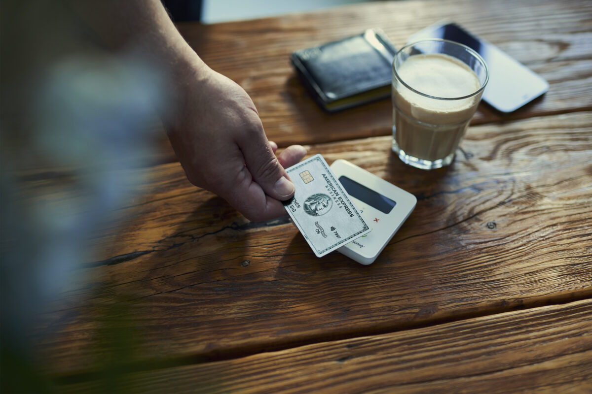 Die Hand einer Person hält eine Business Card in der Hand und bezahlt damit.