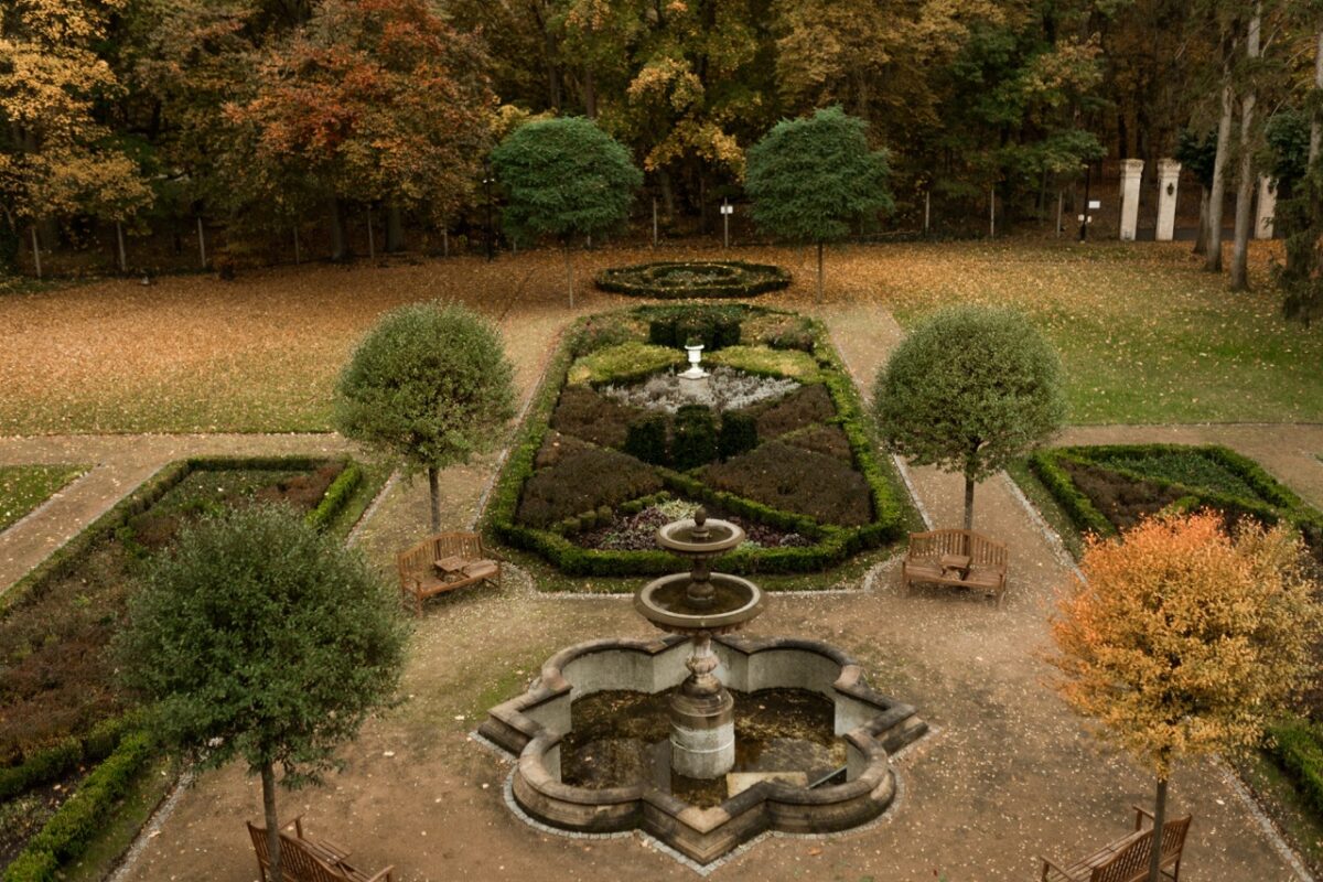 Weitläufiger Schlossgarten von Manowce mit gepflegten Rasenflächen.