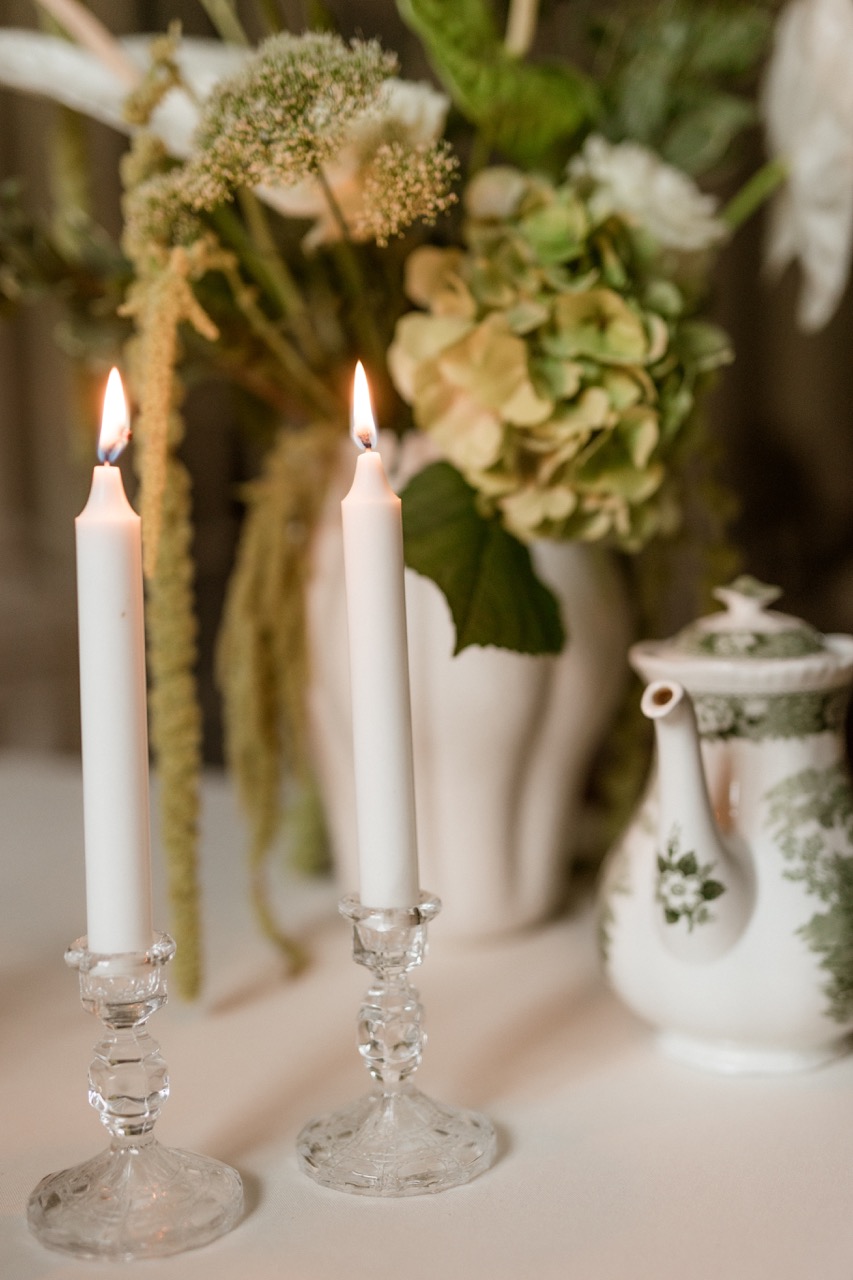 Festlich gedeckter Hochzeitstisch im Schloss Manowce mit weißen Blumenarrangements, edlem Porzellan.