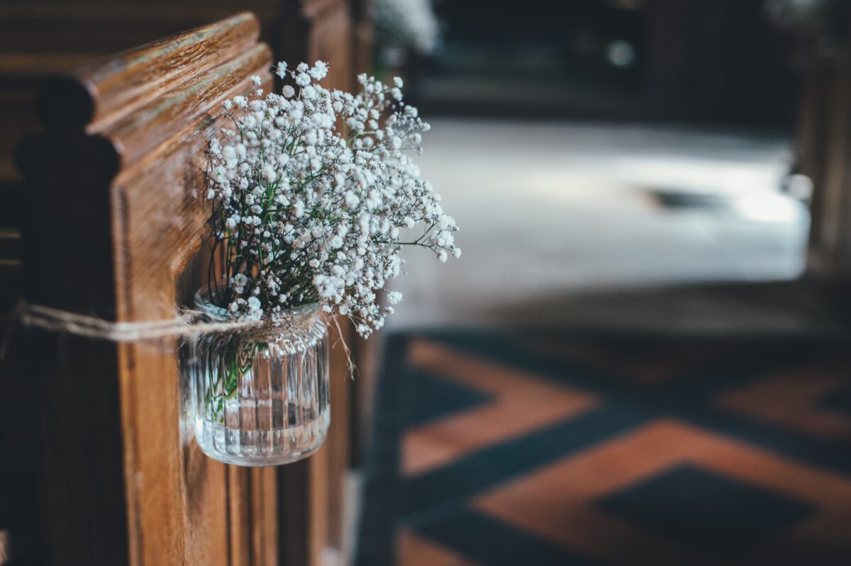 Schleierkraut in einem Einmachglas auf den Kirchenbänken.